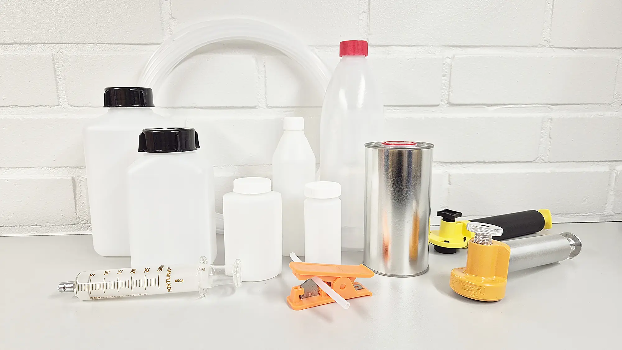 Fluidlabin tuotteet: HDPE näytepullot, imupumppu, imupumpun letku, letkuleikkuri ja kaasutiivisruisku